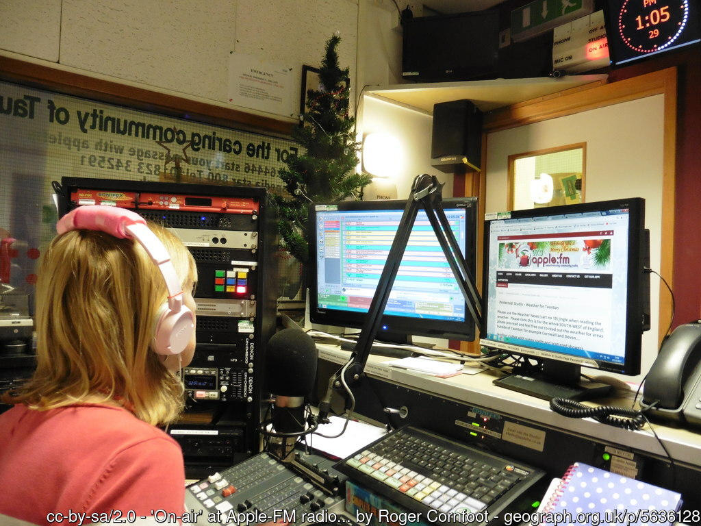 Radio Station DJ sat at mixing desk inside studio